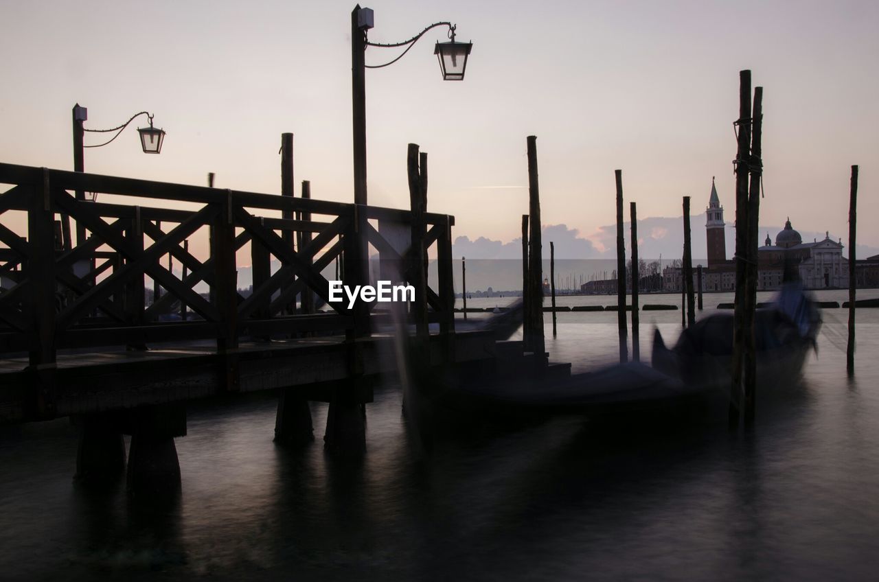 Gondola in grand canal against sky at dusk