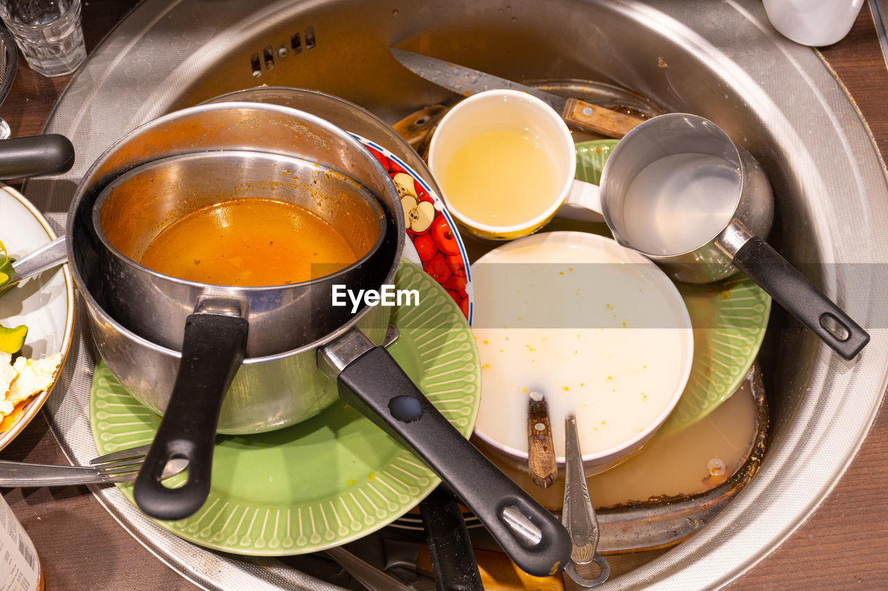 Dirty cutlery, dishes, plates and pans in a sink during quarantine or lockdown, need to wash