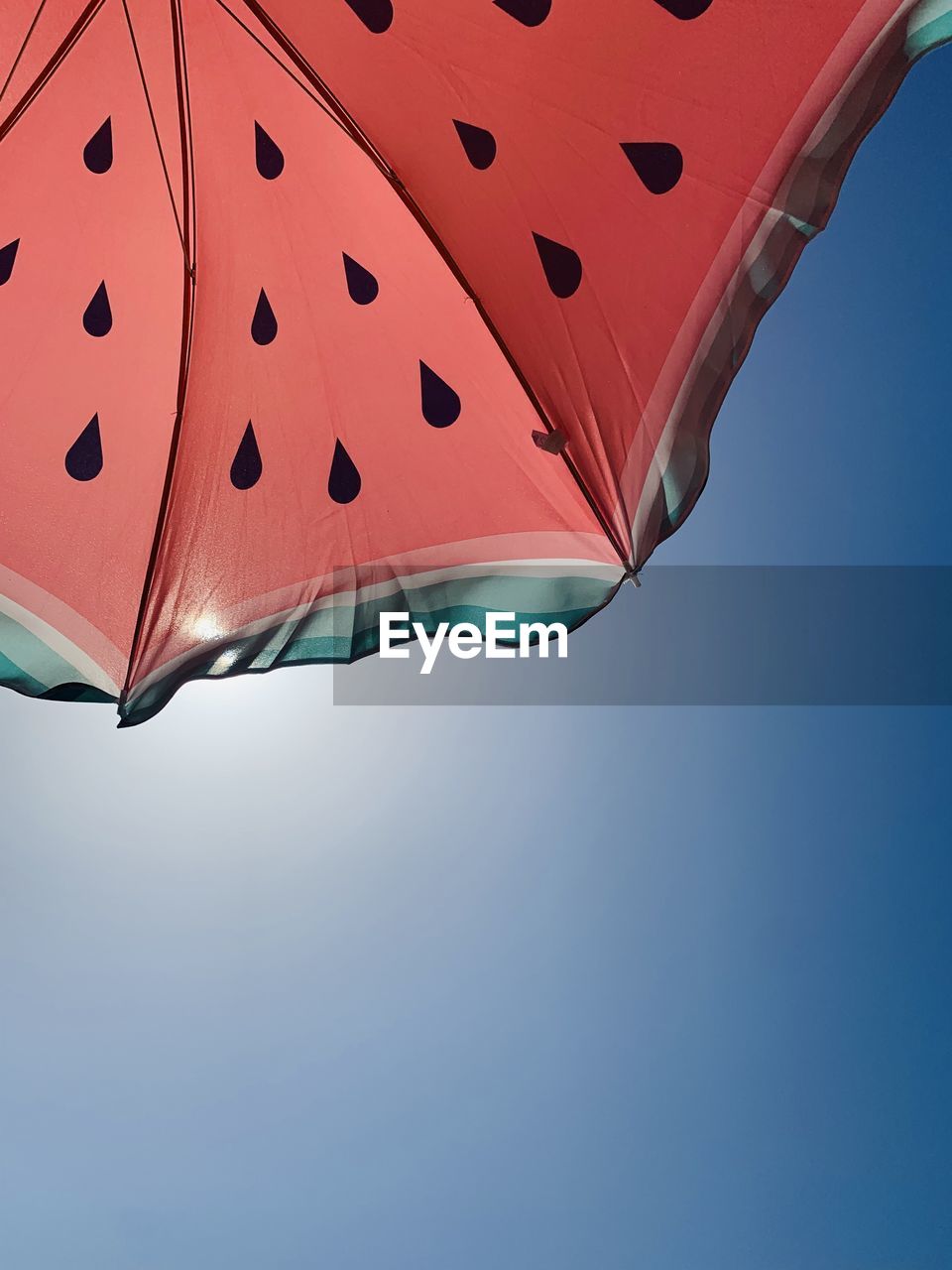 LOW ANGLE VIEW OF PARASOL AGAINST CLEAR BLUE SKY
