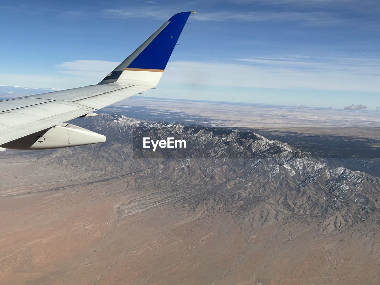 air vehicle, airplane, aircraft wing, transportation, mode of transportation, travel, flying, sky, aircraft, aerial view, environment, vehicle, nature, cloud, airliner, journey, scenics - nature, wing, air travel, aviation, landscape, land, no people, motion, day, mid-air, jet aircraft, beauty in nature, outdoors, blue, travel destinations, vacation, trip, holiday, on the move, mountain, horizon