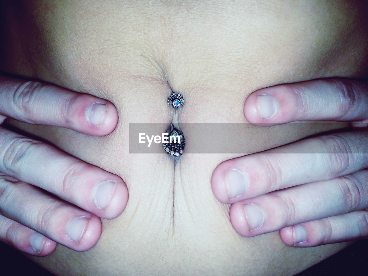 Midsection of teenage girl with belly piercing