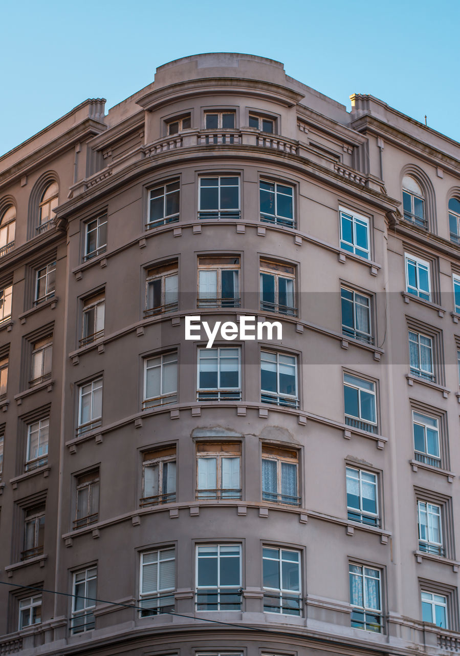 Low angle view of apartment building against blue sky