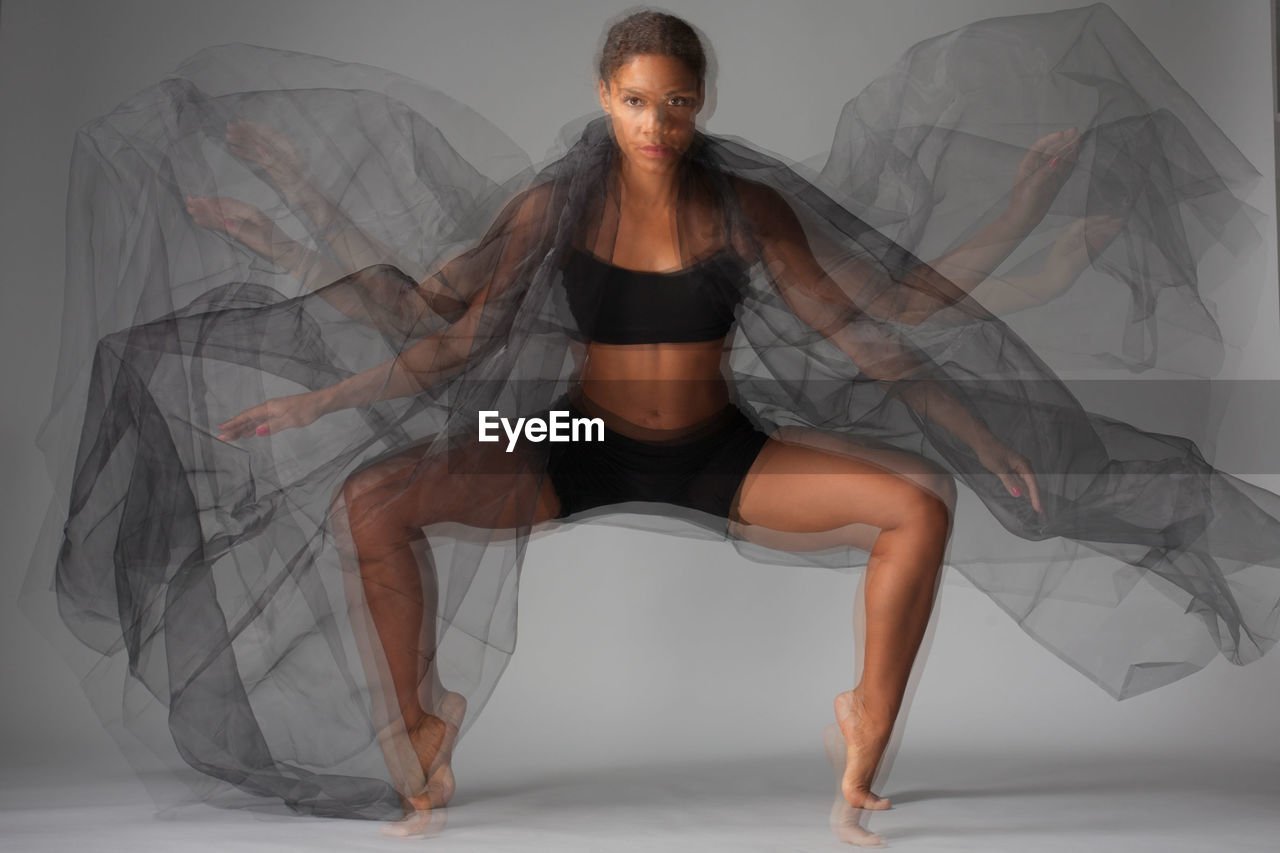 Multiple image of dancer performing against gray background