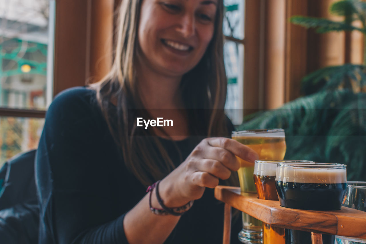 Close-up of smiling woman holding drink in glass