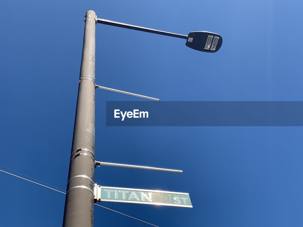 LOW ANGLE VIEW OF CRANE AGAINST BLUE SKY