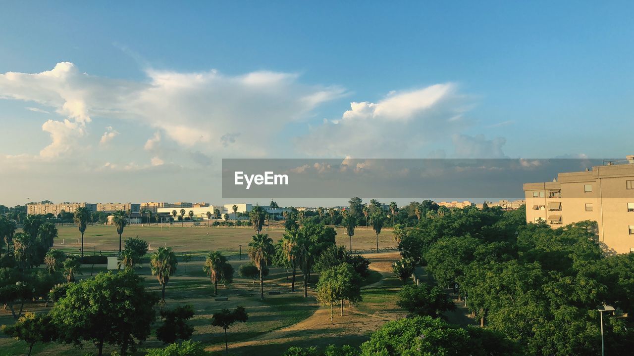 Panoramic view of trees and buildings against sky