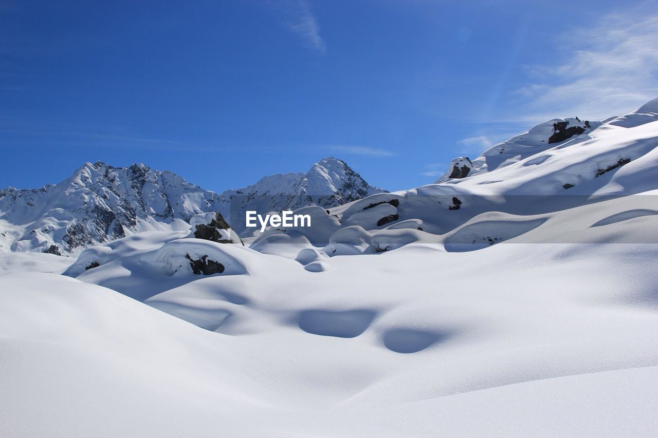 Idyllic shot of snowcapped mountains and landscape against sky