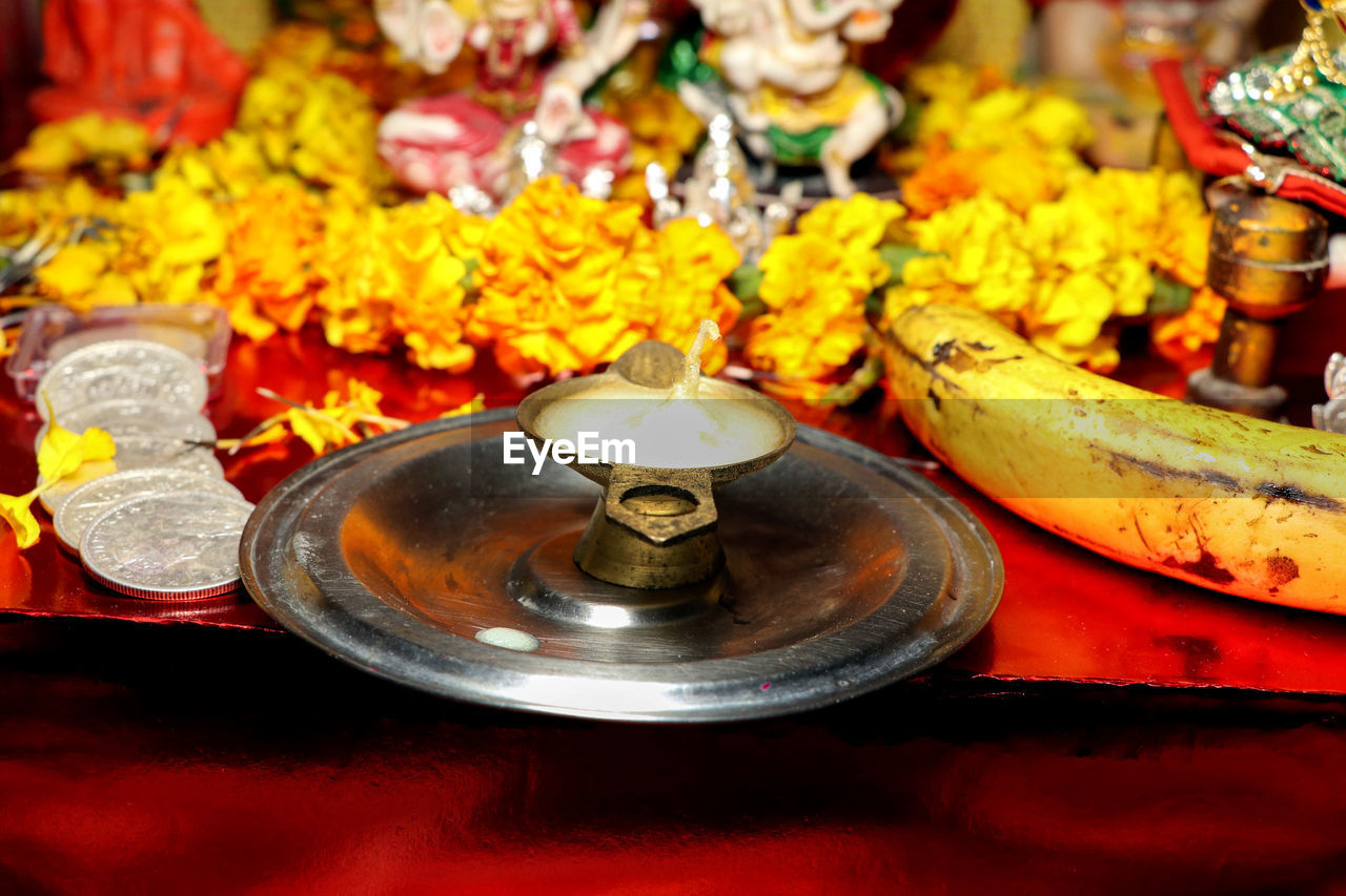 religion, belief, spirituality, no people, temple - building, flower, tradition, meal, incense, oil lamp, close-up, indoors, food, focus on foreground, ceremony