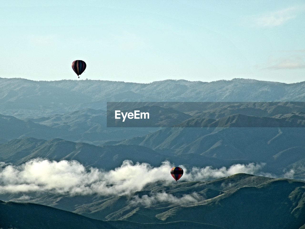 Kite flying over mountains against sky