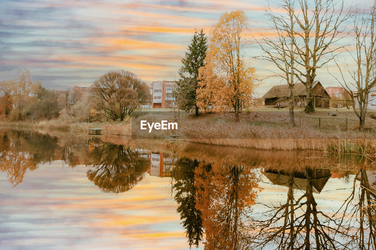 Scenic view of lake by buildings against sky