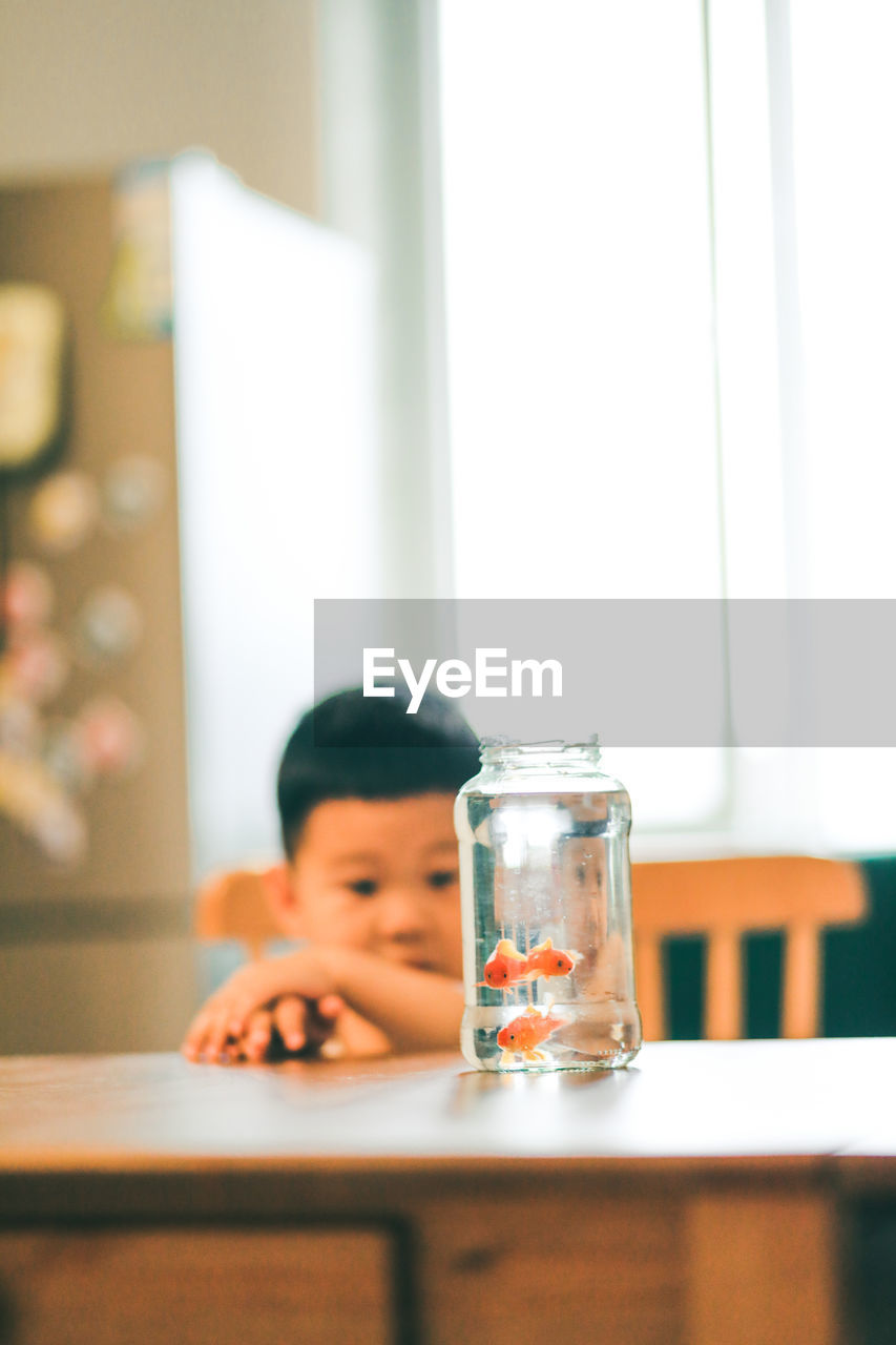 Portrait of boy drinking glass on table