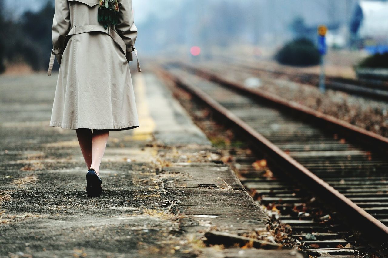 Low section of woman walking at railroad station platform