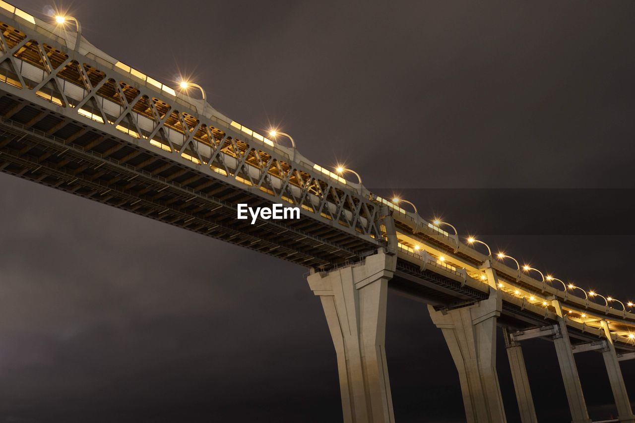 Low angle view of illuminated bridge against sky at night