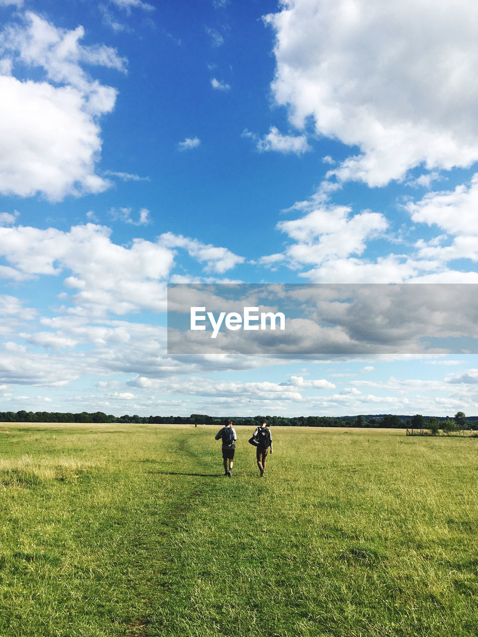 WOMAN STANDING ON FIELD AGAINST SKY