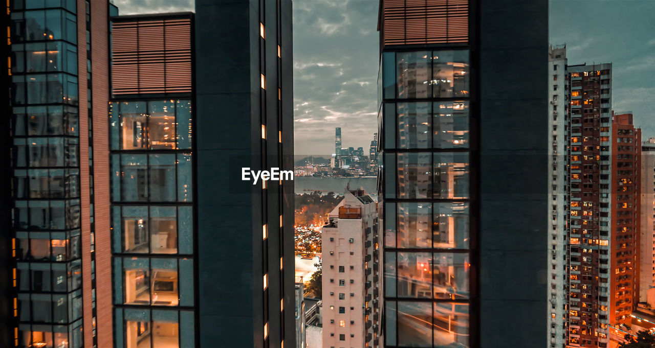 Buildings against sky seen through glass window