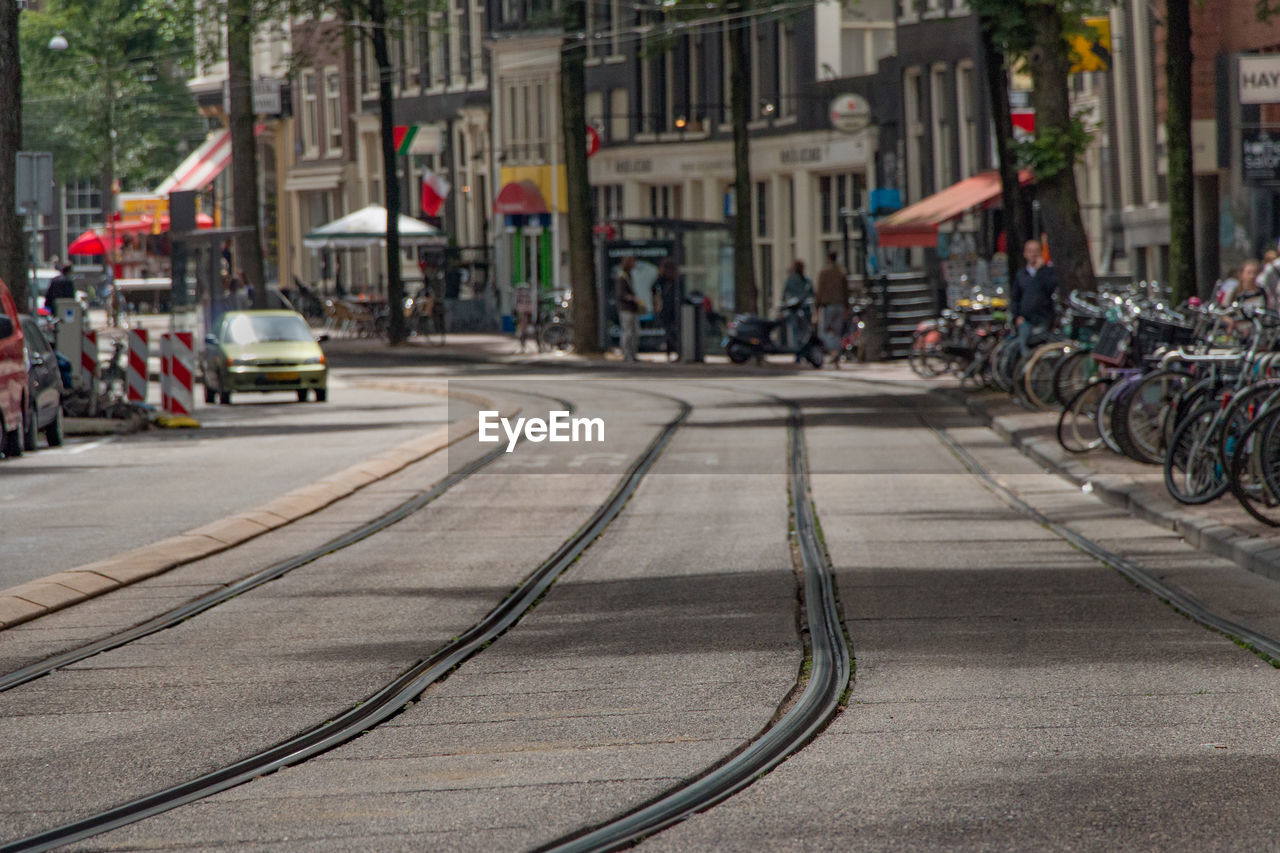 Railroad tracks on city street against building