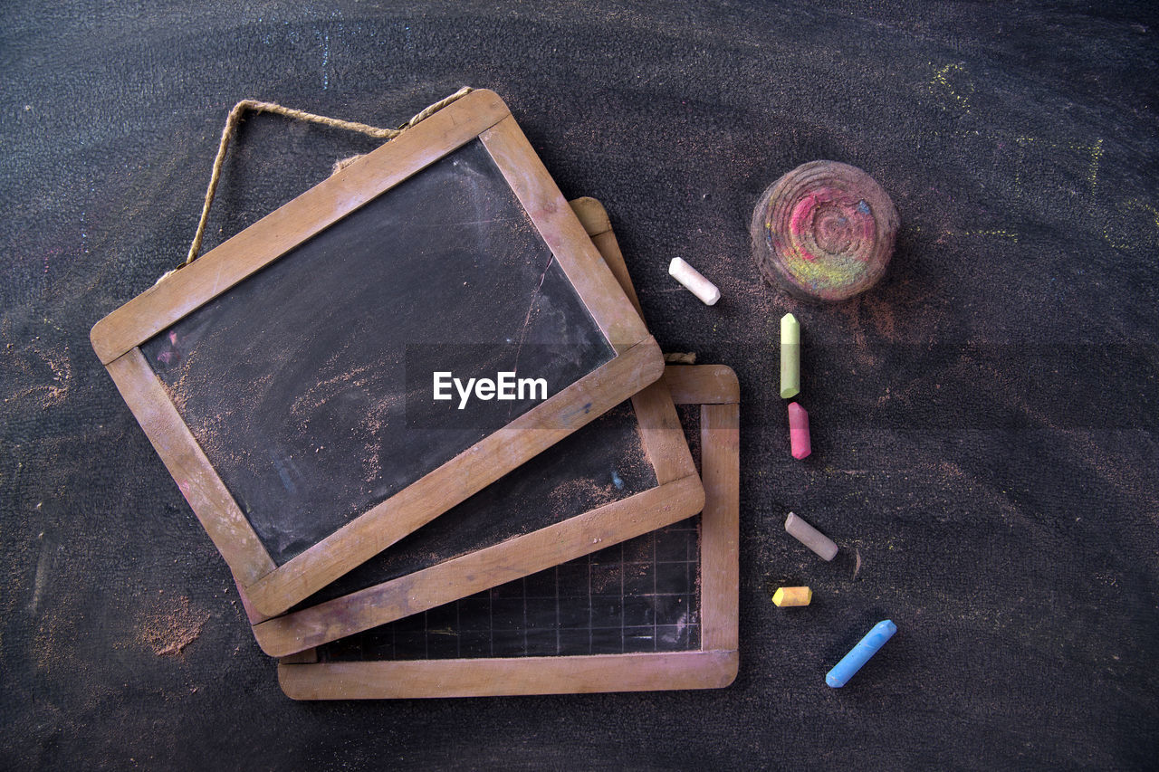 Directly above shot of writing slate with chalks on table