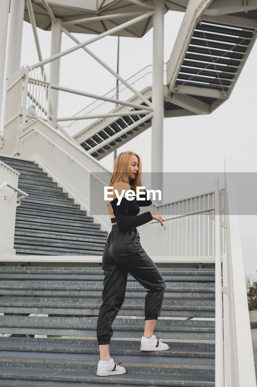 Full length of woman standing on staircase