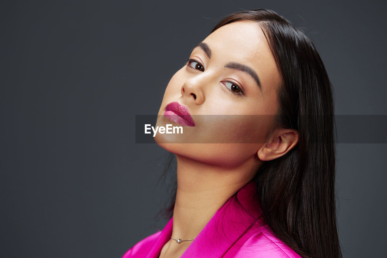 close-up portrait of beautiful young woman against black background