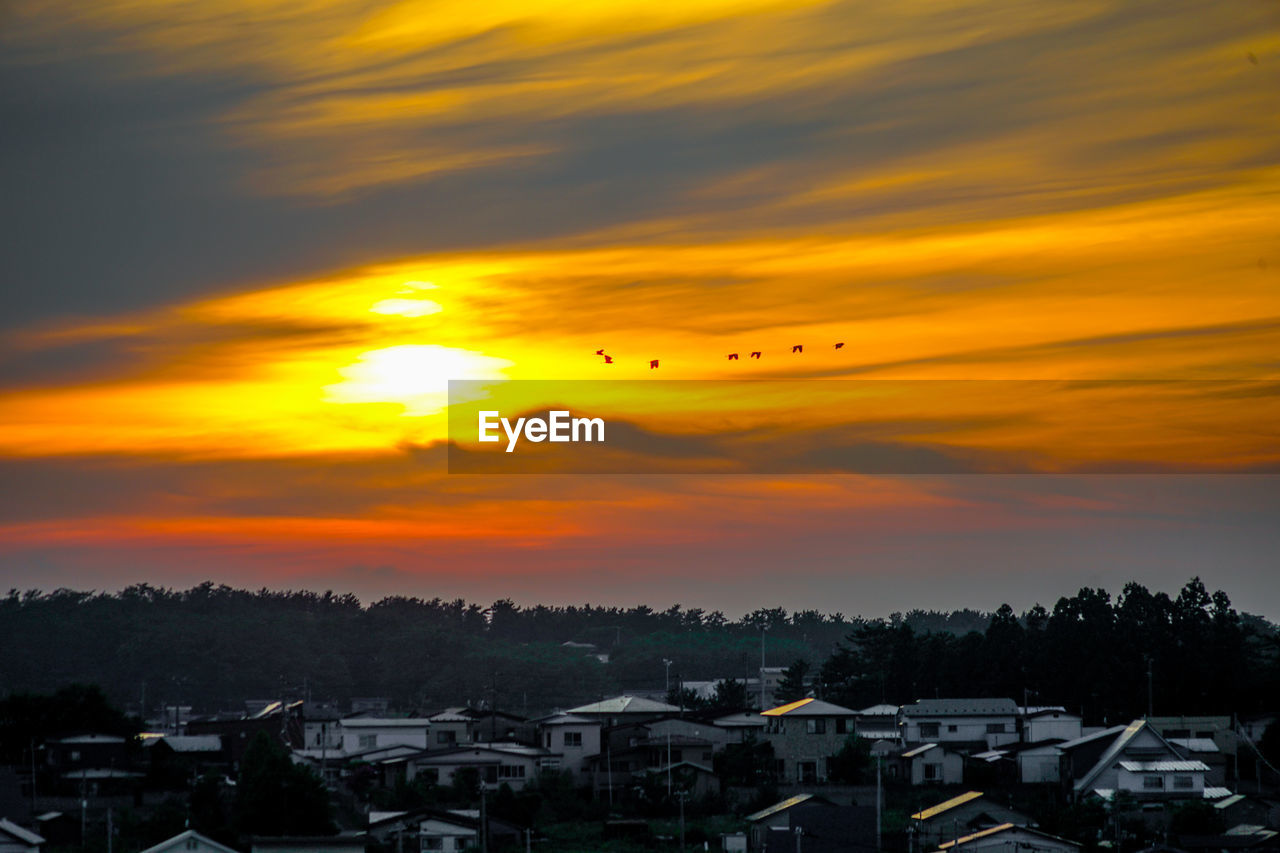 high angle view of townscape against cloudy sky during sunset