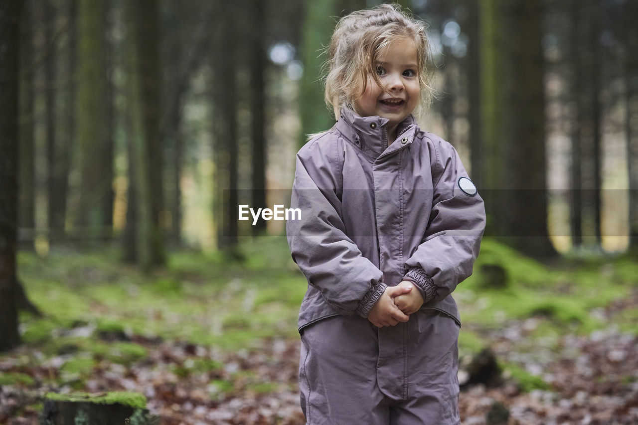 Adorable child enjoys a walk in the forest in denmark