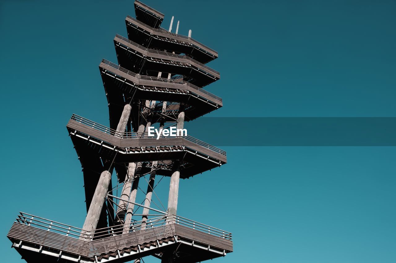 Low angle view of incomplete building against clear blue sky