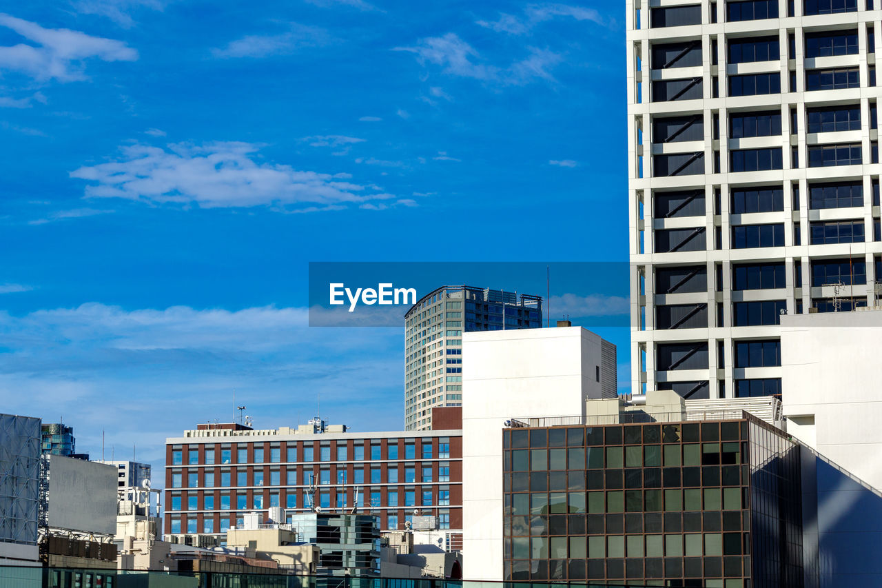 Buildings in city against blue sky