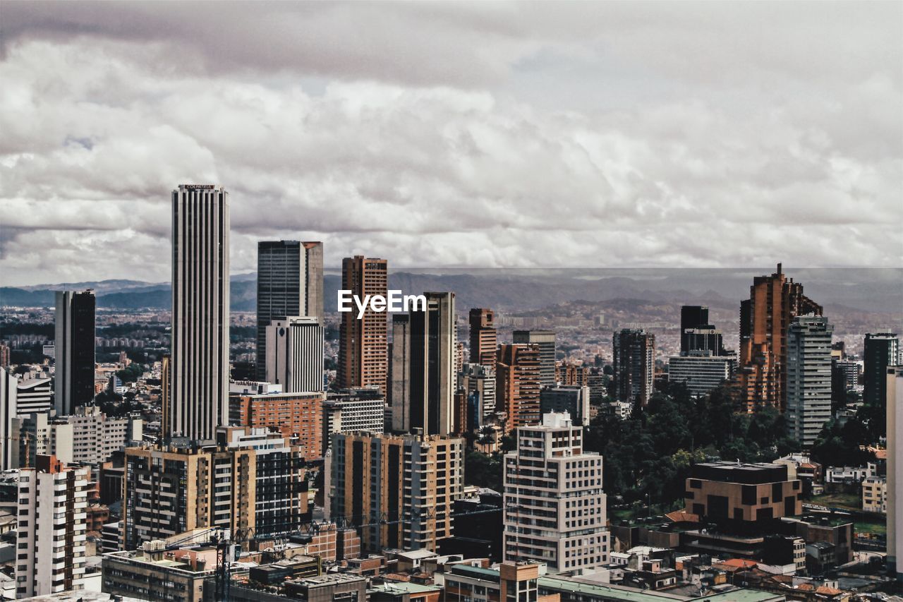 View of cityscape against cloudy sky