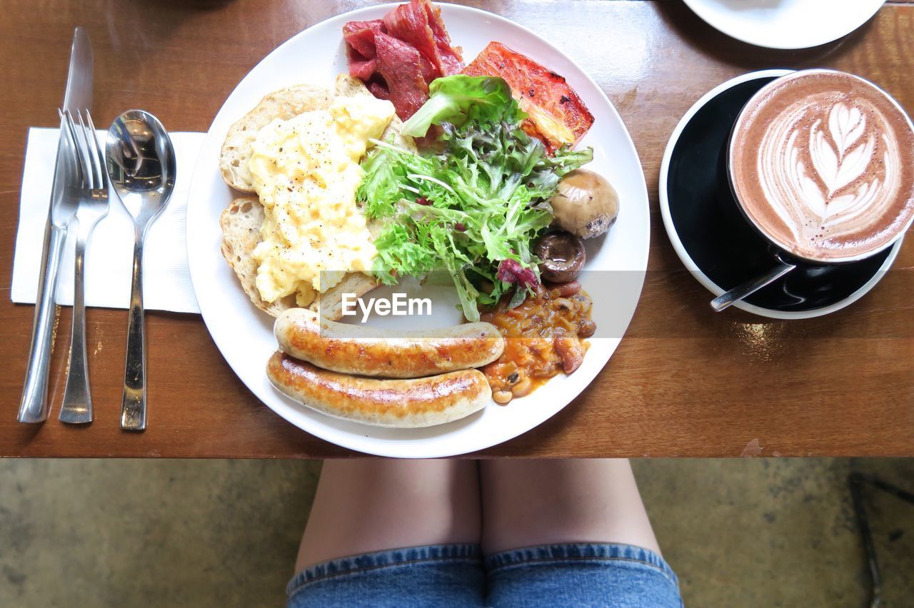 Low section of person with breakfast on table