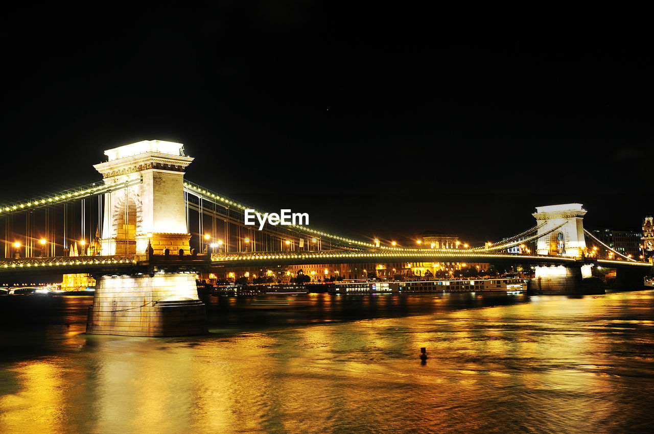 Illuminated chain bridge over danube river at night