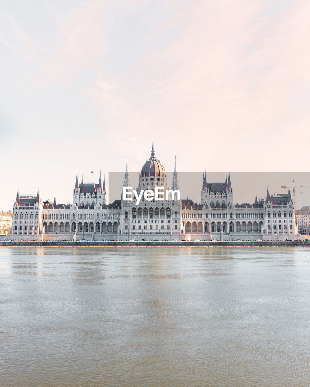 Hungarian parliament building by river against sky