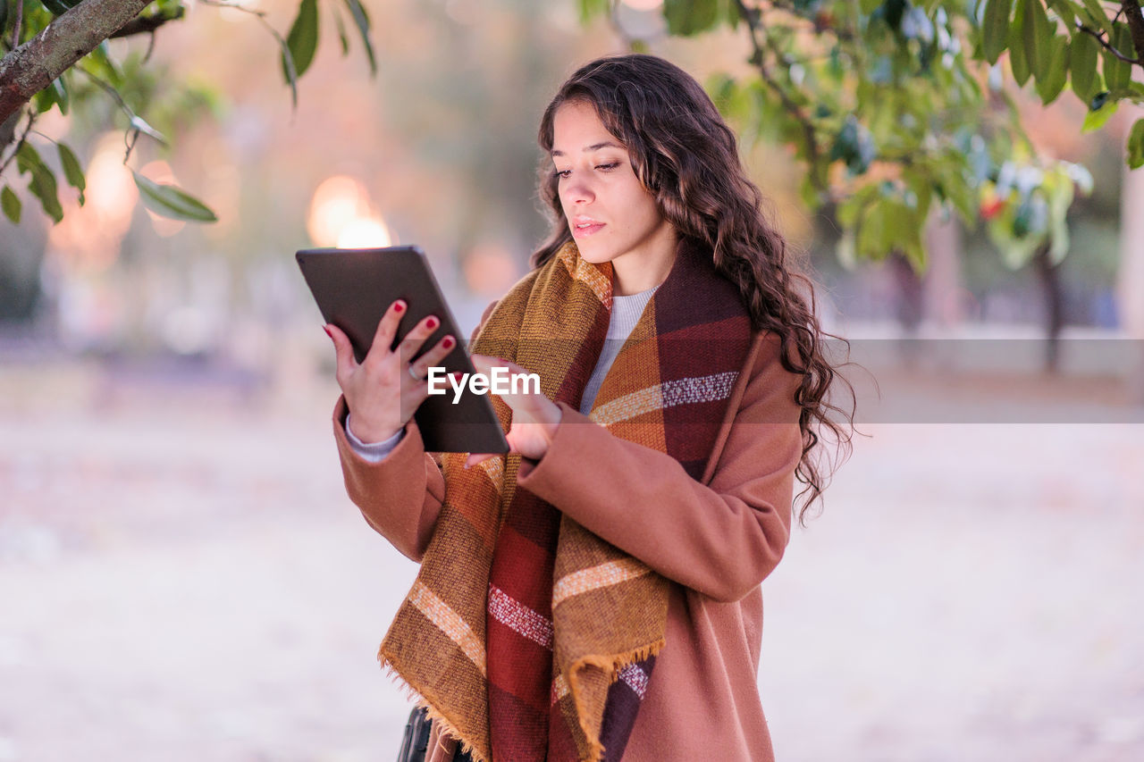 Young woman using digital tablet outdoors