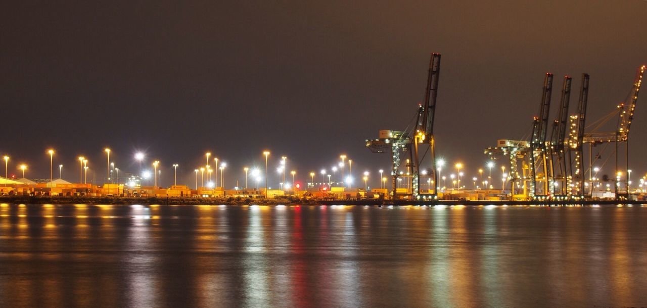 VIEW OF ILLUMINATED CITY AT WATERFRONT