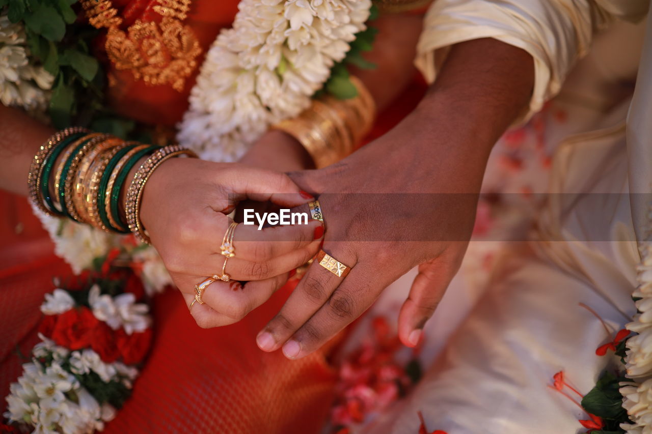 midsection of bride and groom