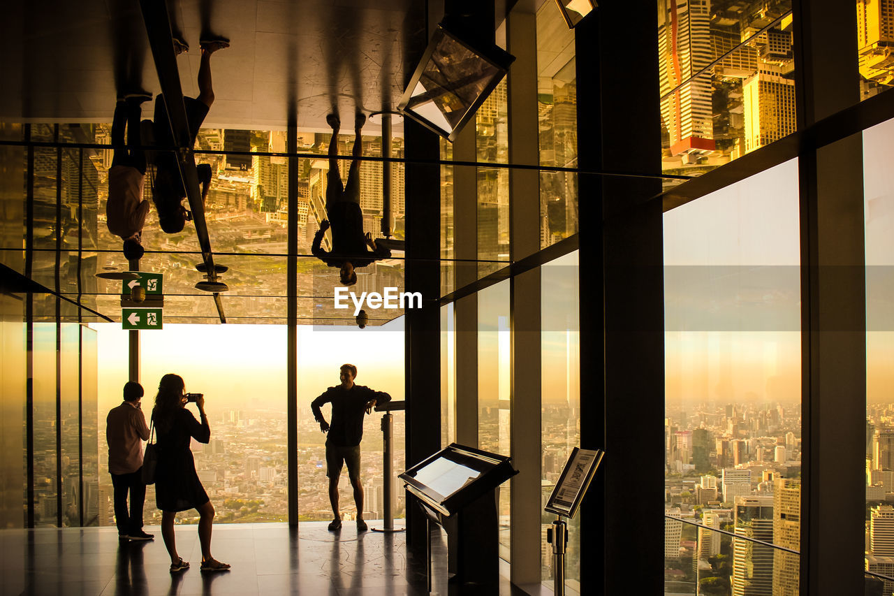 SILHOUETTE PEOPLE WALKING ON MODERN GLASS BUILDING