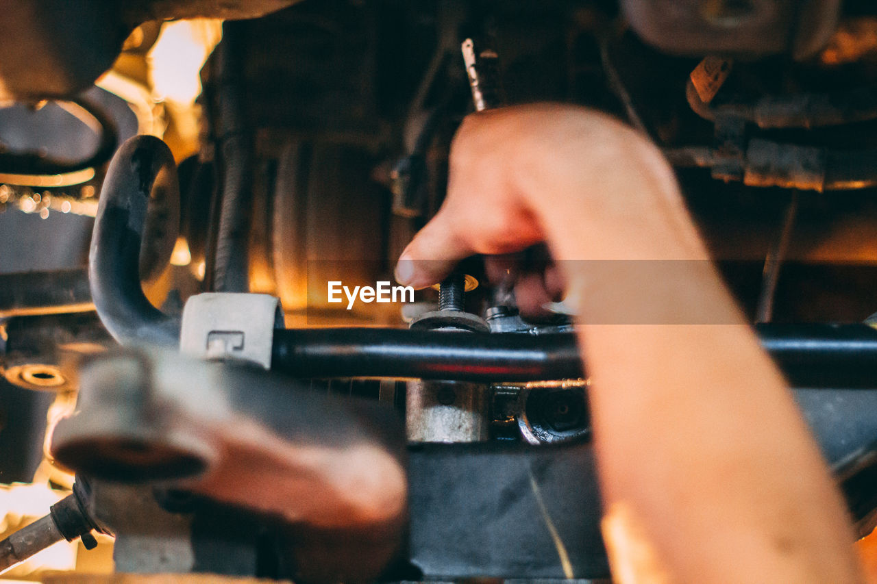 Cropped hand of man working on machine