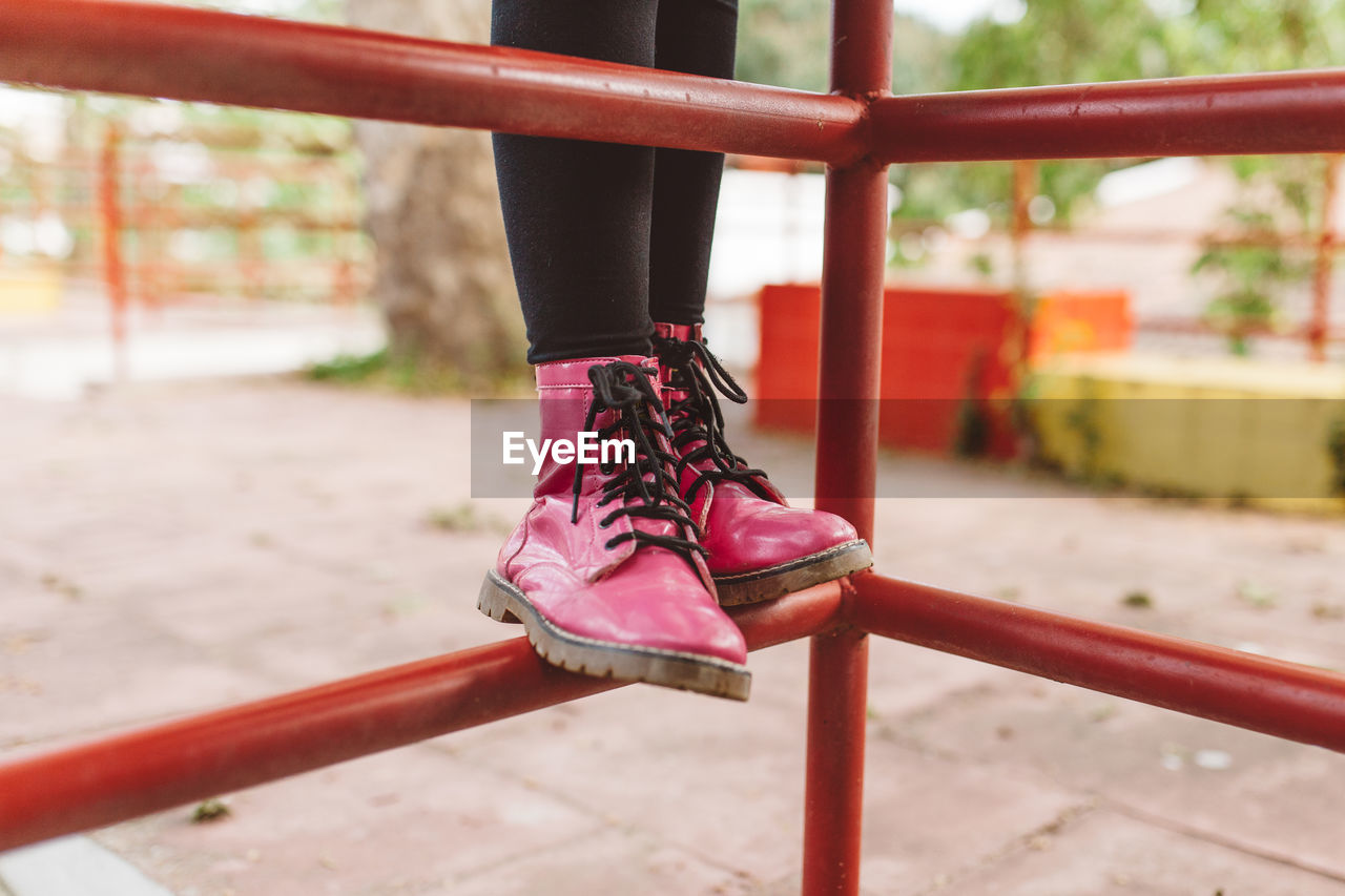 Low section of person wearing red shoes standing on jungle gym