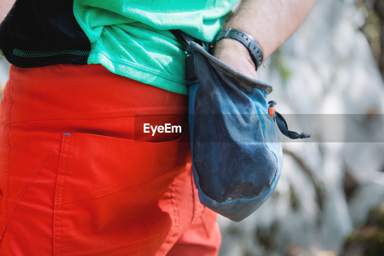 Close-up of a bag of magnesia hanging on a climber's belt in the forest on a trainer. pouch 