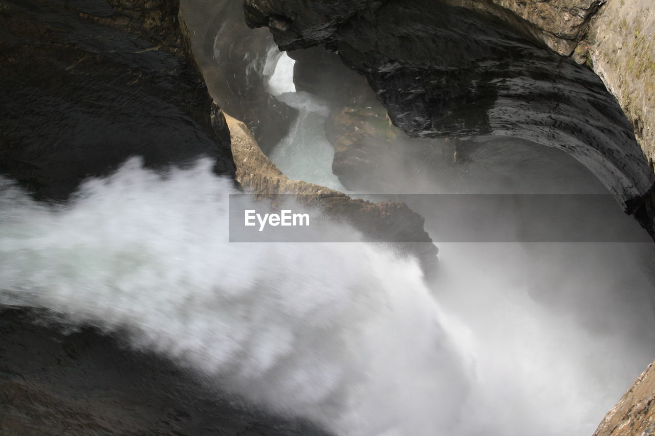 LOW ANGLE VIEW OF WATERFALL IN ROCK