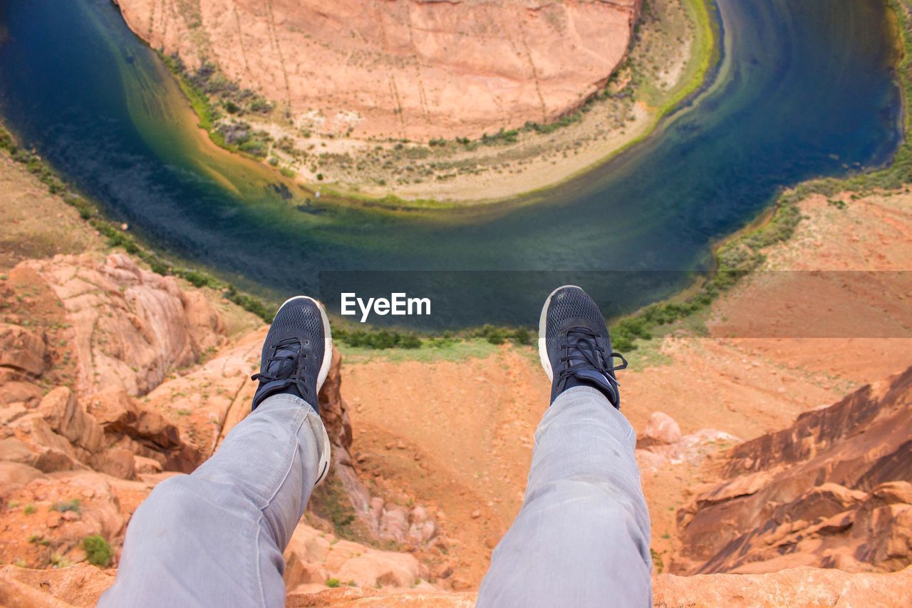 Low section of man sitting against horseshoe bend