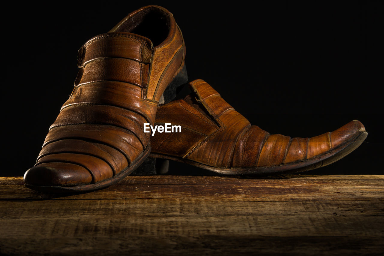 CLOSE-UP OF SHOES ON TABLE