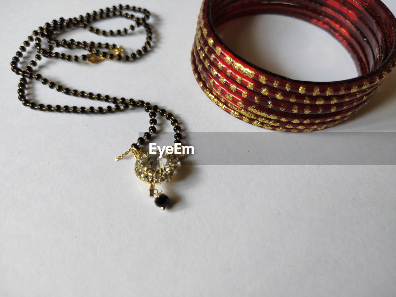 Necklace and bangles on plain background. mangalsutra and bangles on white background.