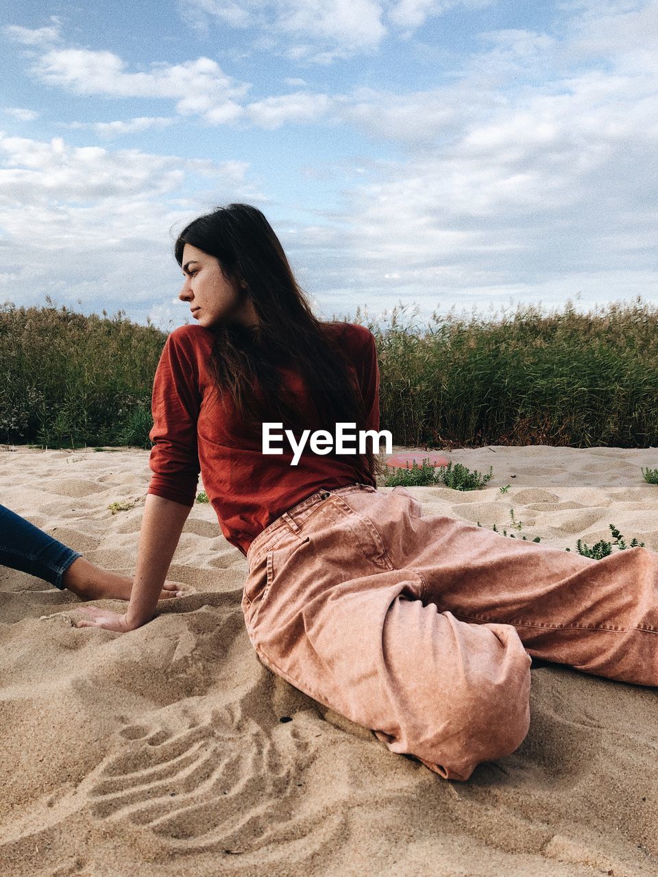 Side view of woman sitting on beach