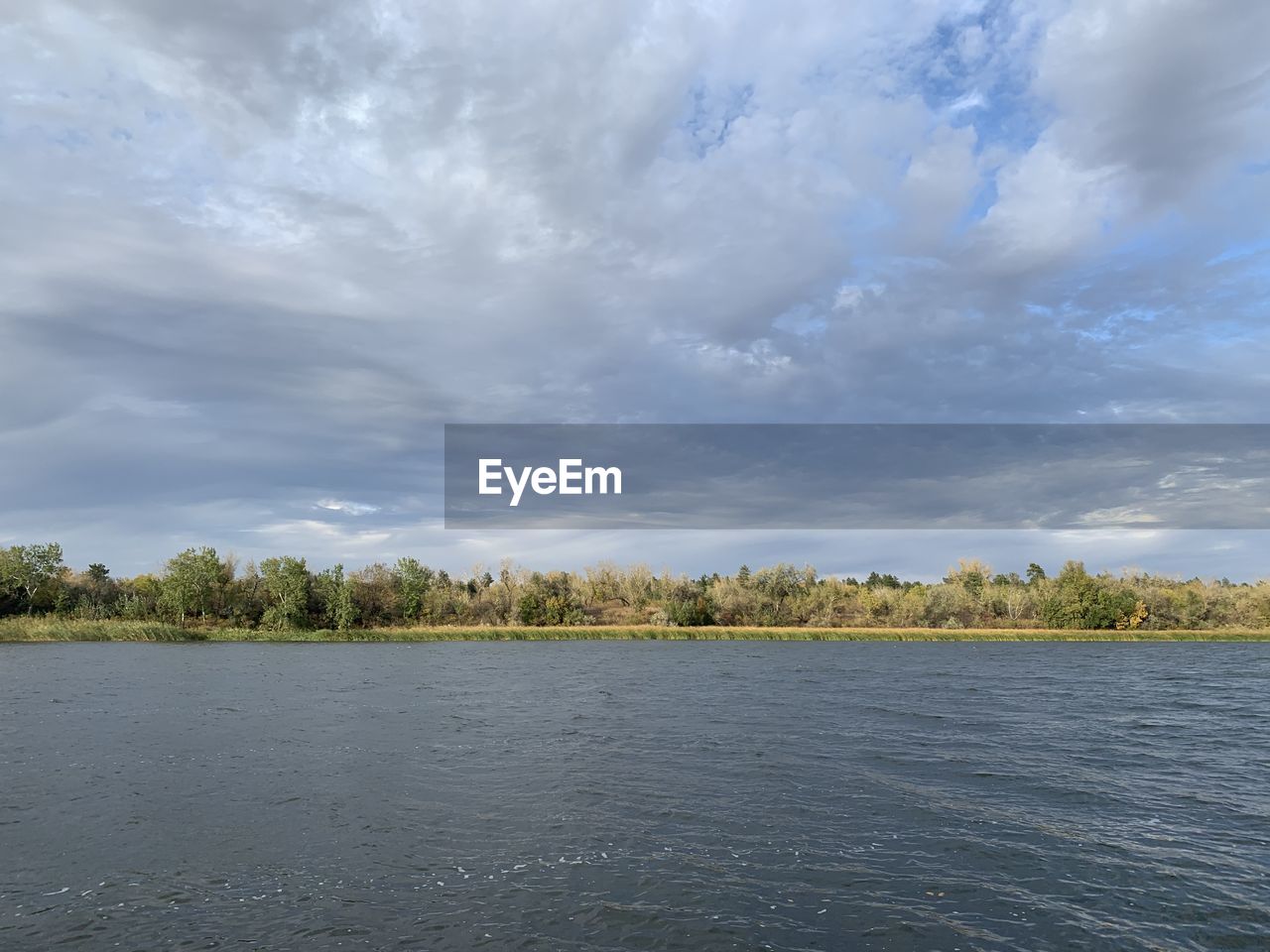 Scenic view of lake by trees against sky