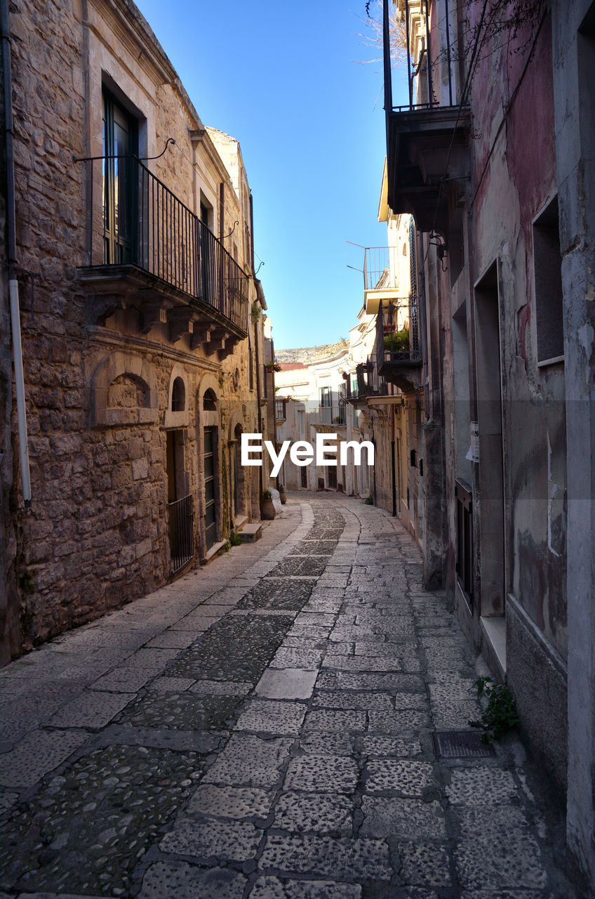 Empty alley amidst buildings in city