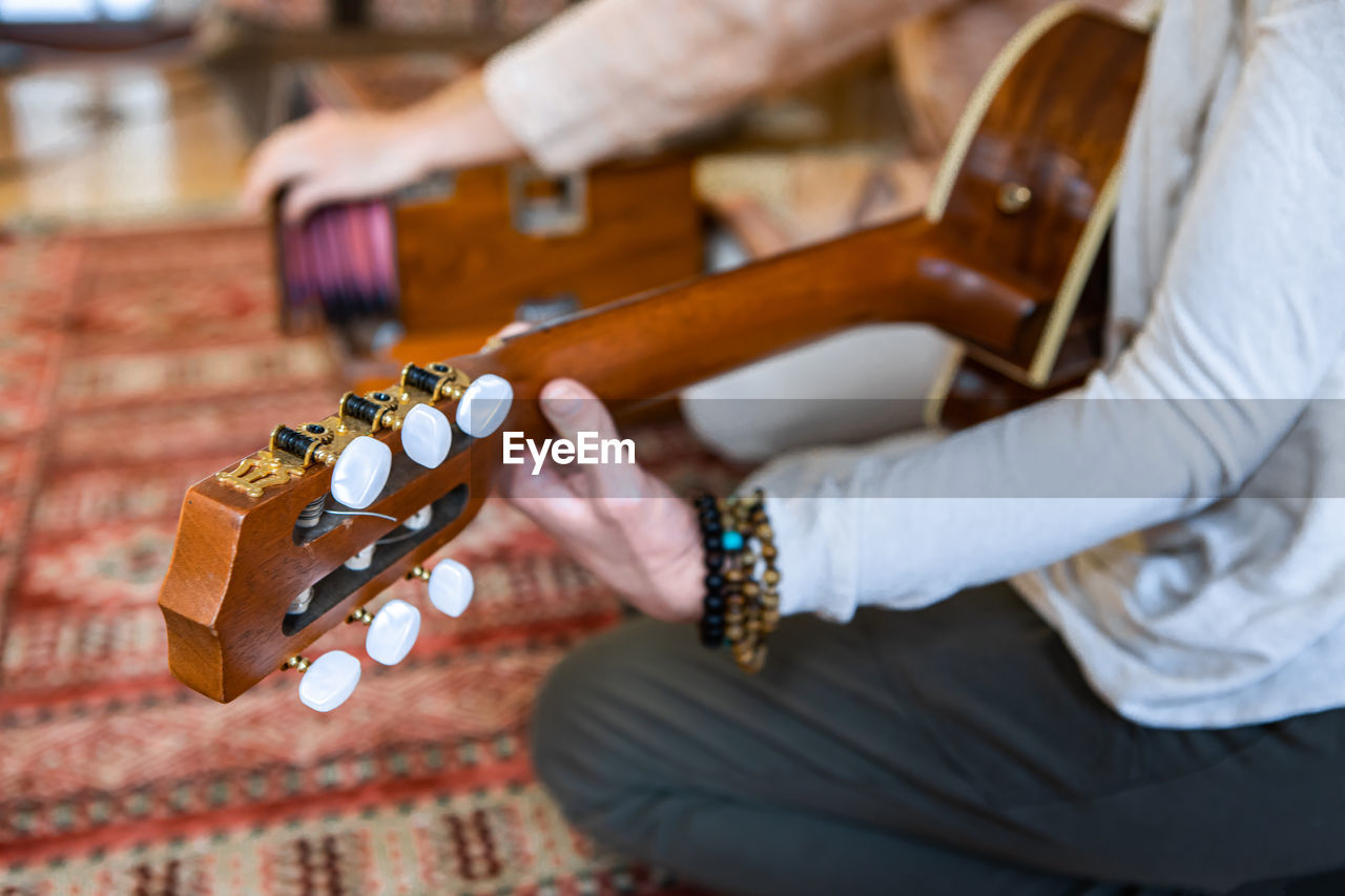 Midsection of woman playing guitar