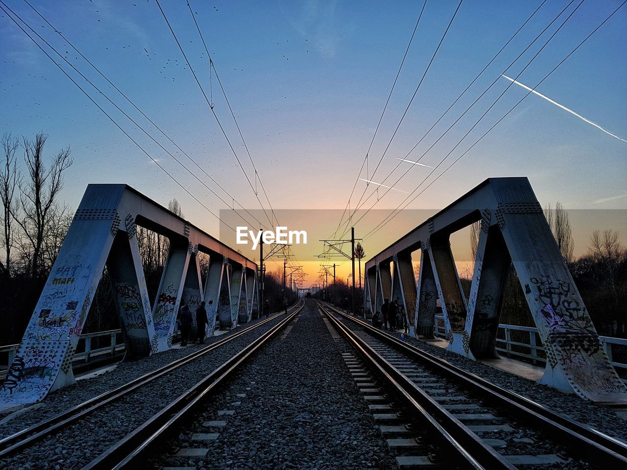 Railroad tracks against sky during sunset