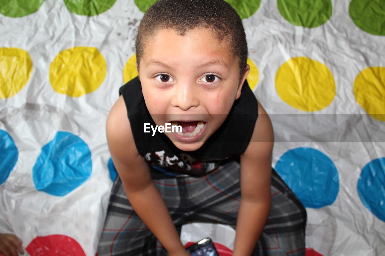 High angle portrait of with mouth open sitting on bed