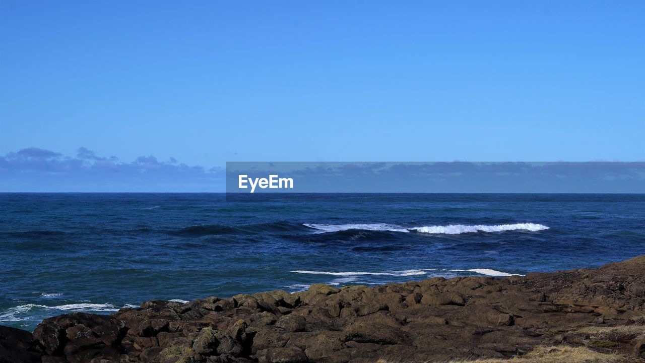 Scenic view of sea against clear blue sky