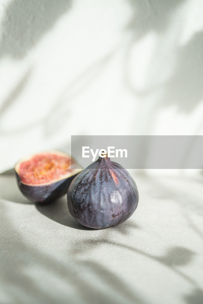 Close-up of figs on white table